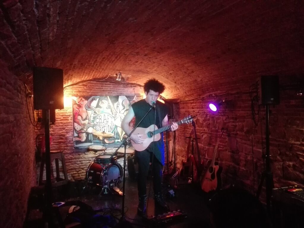Chanteur expressif avec sa guitare au Craft à Barcelone